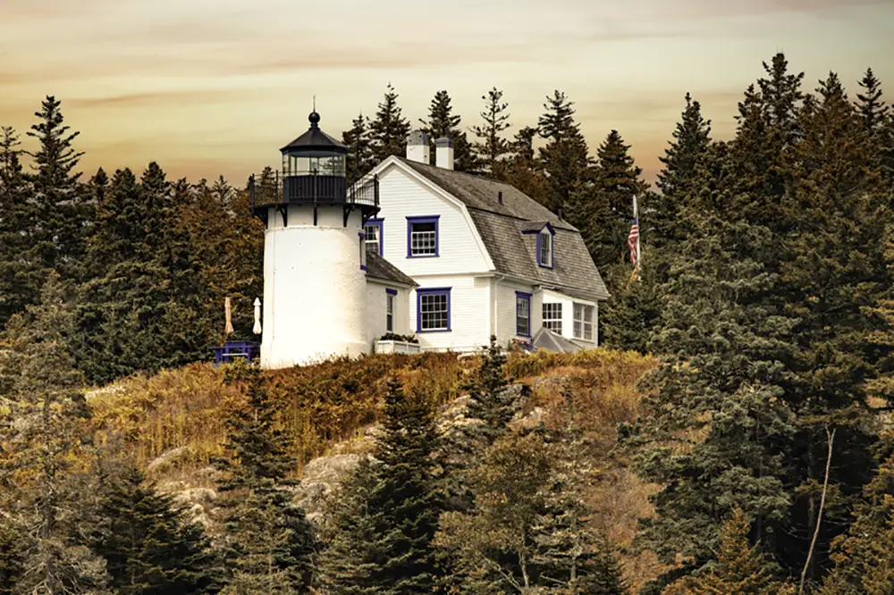 Bear Island Lighthouse in Maine as seen against a golden orange sky