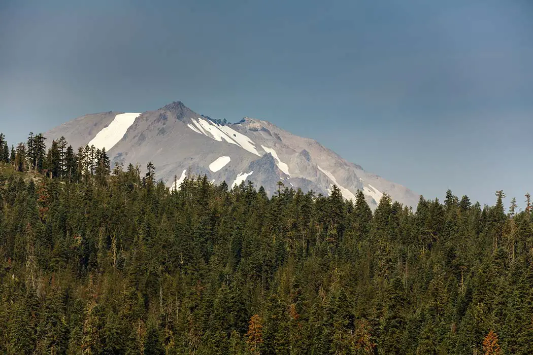 Snow capped volcano rises above Alpine forest. Best Photographic Spots In Lassen Volcanic National Park
