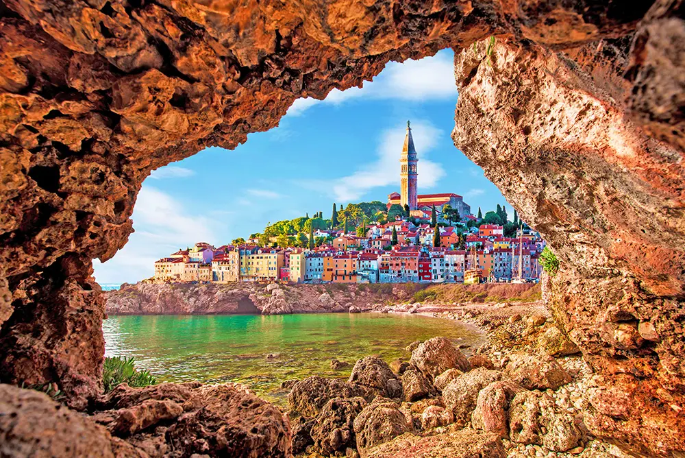 View with old clock towe in Piran through a rock hole.The best Photography spots in Slovenia