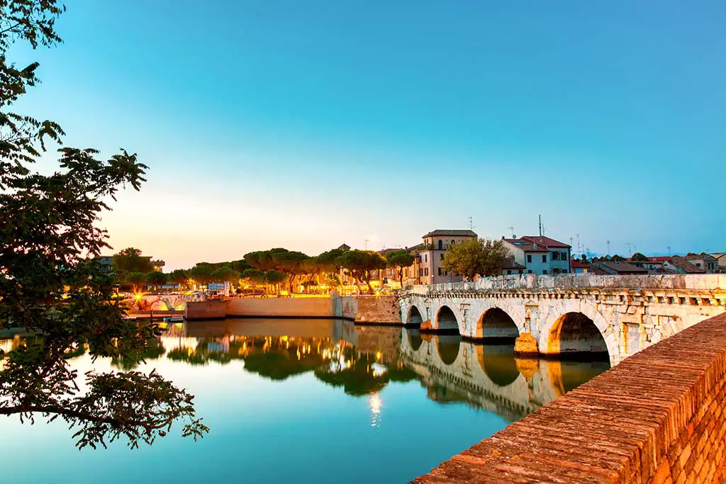 Historical roman Tiberius bridge over Marecchia river during sunset in Rimini. Best Photography Spots in Rimini