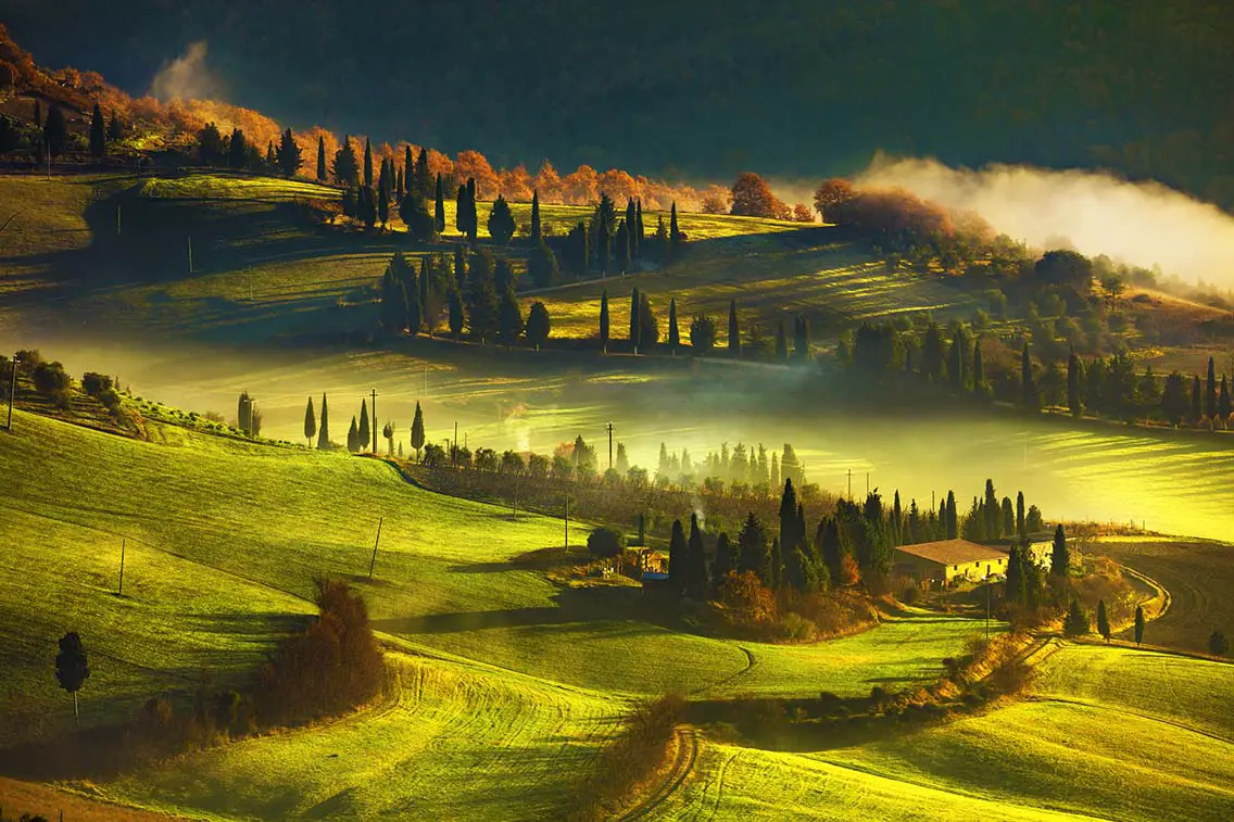 Tuscany foggy morning farmland and cypress trees country landscape. Best Natural Wonders in Italy