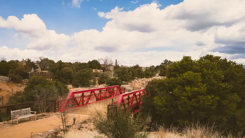 Path and red steel bridge in Santa Fe Botanical Garden. Best Photography Spots in Santa Fe New Mexico.